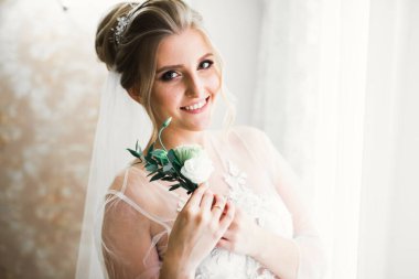 Beyaz elbiseli lüks gelin düğün törenine hazırlanırken poz veriyor..