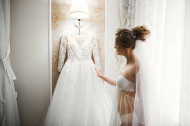 Beyaz elbiseli lüks gelin düğün törenine hazırlanırken poz veriyor..