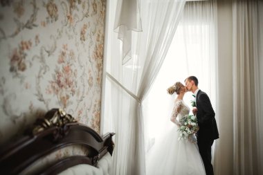 Güzel gelin ve damat düğün günlerinde kucaklaşıp öpüşürler..