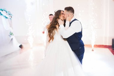 Güzel gelin ve damat düğün günlerinde kucaklaşıp öpüşürler..