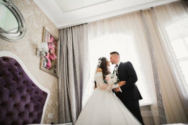 Güzel, genç bir çift ellerinde çiçeklerle poz veriyorlar..