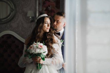 Güzel, genç bir çift ellerinde çiçeklerle poz veriyorlar..