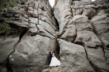Dağların arka planında sevgi dolu bir koca ve kadın. Sevgili çift duygusal olarak vakit geçirir..