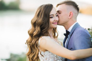 Düğün çifti, damat ve gelin kucaklaşıyor, nehir kenarında..