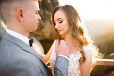 Doğadaki düğün çifti birbirine sarılıyor. Beyaz elbiseli güzel bir kız. Takım elbiseli adam.