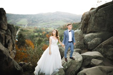 Dağların arka planında sevgi dolu bir koca ve kadın. Sevgili çift duygusal olarak vakit geçirir..