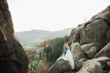 Harika bir gelin damada poz veriyor ve harika manzaralı dağlarda eğleniyor. Mesajlaşacak yer, düğün çifti..