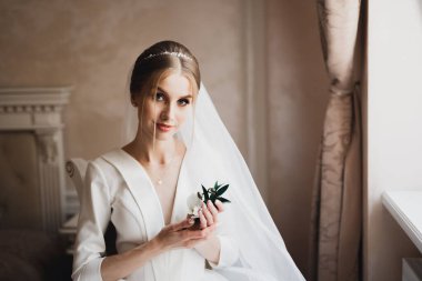 Gelin çiçekli büyük ve güzel bir düğün buketi tutuyor..