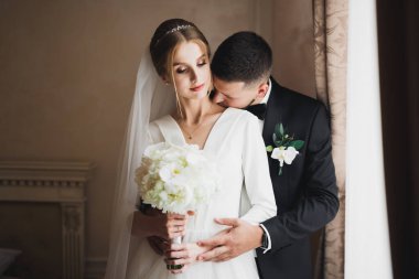 Güzel, genç bir çift ellerinde çiçeklerle poz veriyorlar..