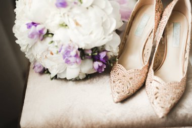 Gül ve diğer çiçekler tha koltuk üzerinde ayakkabı ile bir buket düğün gelinler.