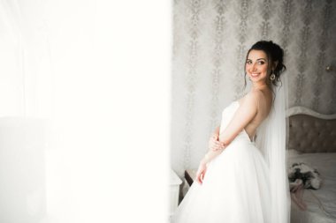 Beyaz elbiseli lüks gelin düğün törenine hazırlanırken poz veriyor..