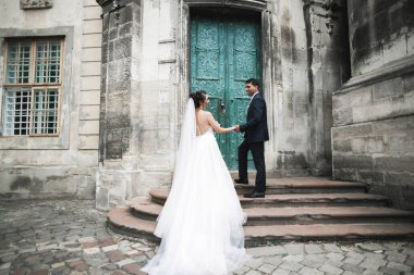 Güzel, mutlu bir düğün çifti, güzel şehirde uzun beyaz elbiseli bir gelin..