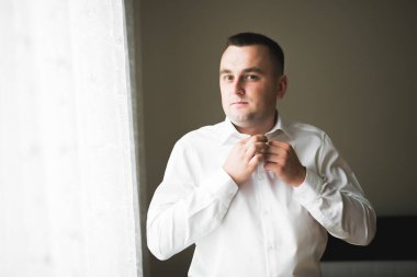 Güzel adam, damat poz veriyor ve düğüne hazırlanıyor..