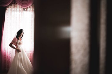 Beyaz elbiseli lüks gelin düğün törenine hazırlanırken poz veriyor..