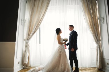 Göz kamaştırıcı mutlu çift birbirine yakın duruyor ve gözlerinin içine bakıyor..