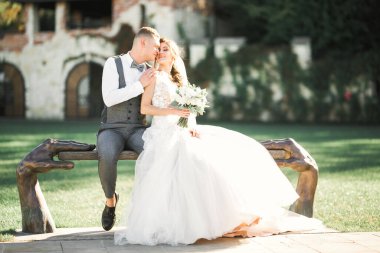 Doğadaki düğün çifti birbirine sarılıyor. Beyaz elbiseli güzel bir kız. Takım elbiseli adam.