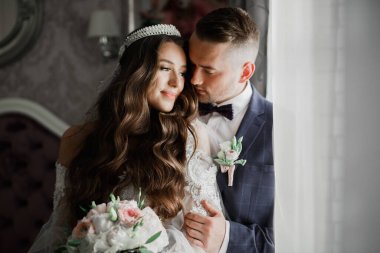 Romantik düğün anı, yeni evli çiftin gülümseyen portresi, gelin ve damadın kucaklaşması.
