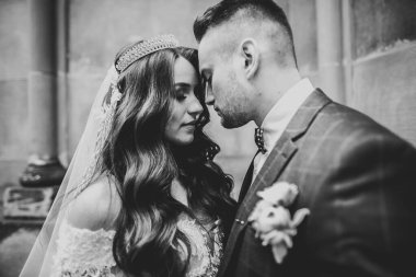 Romantik düğün anı, yeni evli çiftin gülümseyen portresi, gelin ve damadın kucaklaşması.