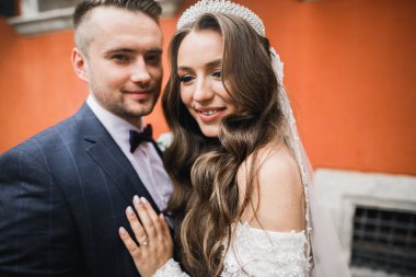 Romantik düğün anı, yeni evli çiftin gülümseyen portresi, gelin ve damadın kucaklaşması.