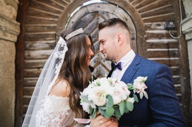 Güzel, genç bir çift ellerinde çiçeklerle poz veriyorlar..