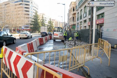 Repair work on a city center sidewalk due to a broken water pipe diverting traffic.