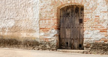 İspanya 'da bir kasaba evinin ön cephesinde eski ahşap kapılar..