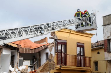Çökmüş bir binada çalışan bir vinçte itfaiyeciler..
