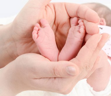 Yeni doğmuş küçük ayaklar annesinin ellerinde.