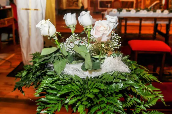 Ornament with white roses and green leaves inside a church to decorate a celebration.