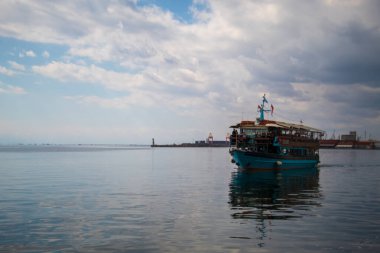 Selanik, Yunanistan - 3.18.2023: Ege Denizi 'nde Selanik kıyısından geçen mavi renkli bir tekne