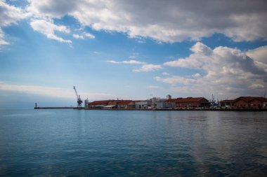 Selanik, Yunanistan - 3.18.2023: Selanik hareketli limanı, ikonik bir vinç ışıldayan suların zeminine karşı dik duruyor