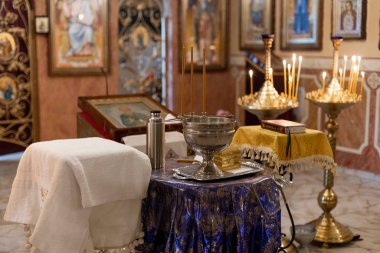 Kilisede vaftiz için mumlarla yapılmış metal bir yazı tipi.