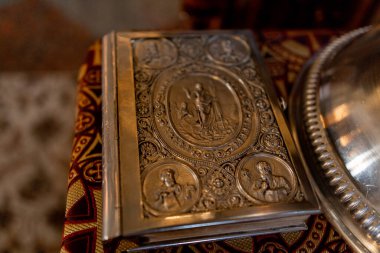 Rahibin masasının üzerinde metal kapaklı bir kilise incili.