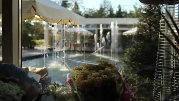 夏の噴水の近くのカフェレストランのテーブル — ストック動画