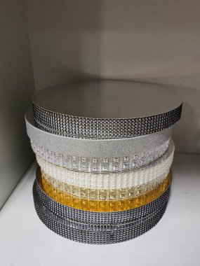 Rafta süslemeler ve yapay elmaslar olan bir pasta standı