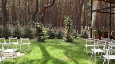 Düğün için kemer ve beyaz sandalyeler.