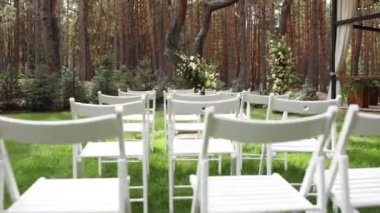 Düğün için kemer ve beyaz sandalyeler.