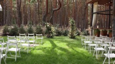 Düğün için kemer ve beyaz sandalyeler.