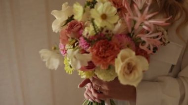 Gelin elinde güzel bir buket çiçek tutuyor.