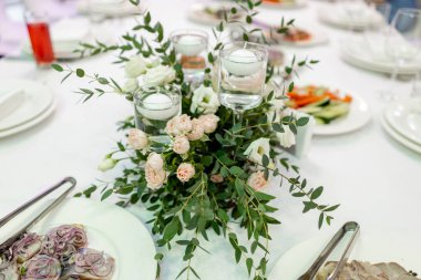 Restorandaki masada çiçek ve mum dekoru.