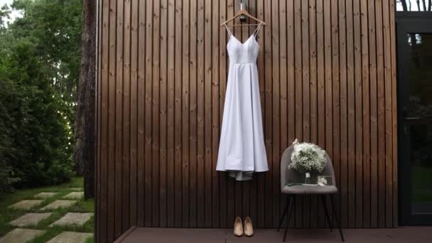 花嫁の白いウェディングドレスはビジョンの壁にかかっています — ストック動画