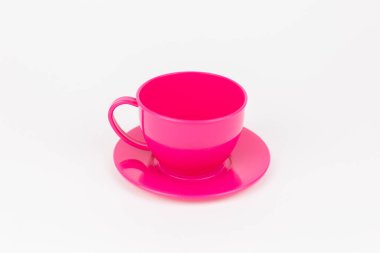 a pink plastic cup with saucer on white background