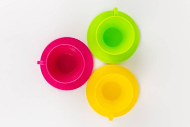 a multi-colored plastic cups and plates on a white background kitchen set