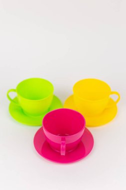 a multi-colored plastic cups and plates on a white background kitchen set