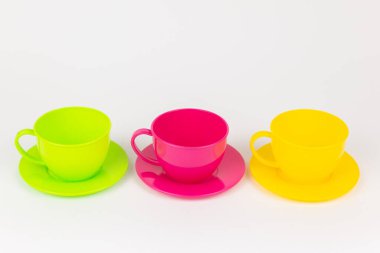 a multi-colored plastic cups and plates on a white background kitchen set