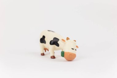 a children's toy figure of a cow on a white background