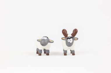 a figure of a sheep and a ram children's toy on a white background