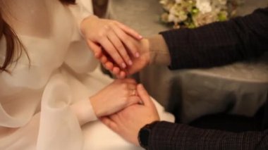 the bride and groom hold hands at the wedding