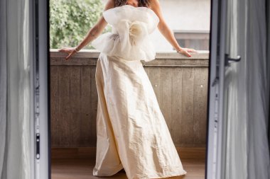 a bride in a white wedding dress in the morning in the room