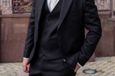 man in a black suit near an office building, a businessman, a lawyer, an attorney